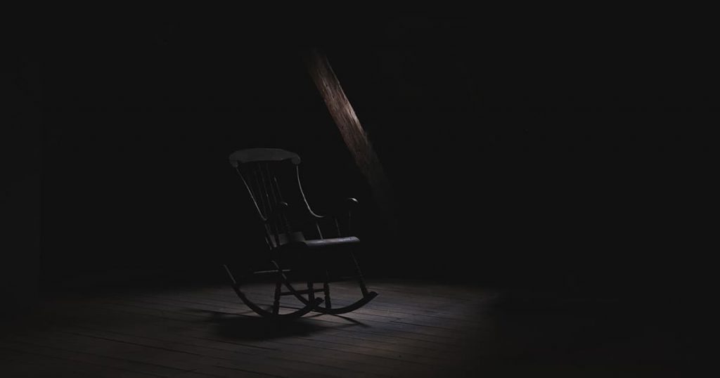 Empty rocking chair in a dark room